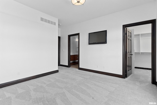 empty room with light carpet, visible vents, and baseboards