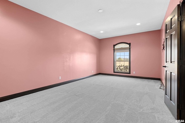 spare room with baseboards, recessed lighting, and light colored carpet