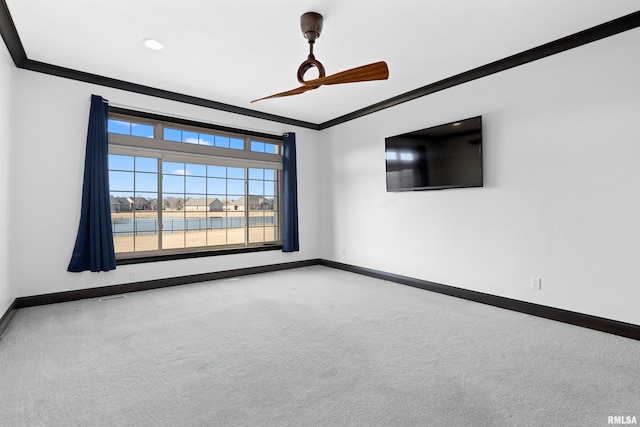 carpeted spare room featuring baseboards and ornamental molding