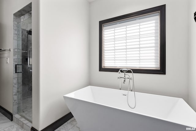 full bath with plenty of natural light, marble finish floor, a freestanding bath, and a stall shower