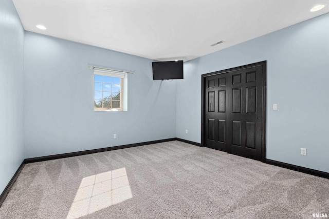 unfurnished bedroom featuring visible vents, baseboards, and carpet flooring
