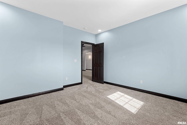 spare room featuring recessed lighting, baseboards, and light carpet