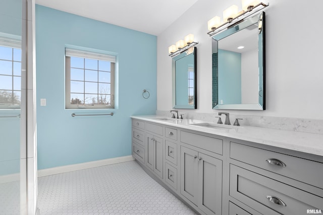 bathroom with double vanity, baseboards, and a sink