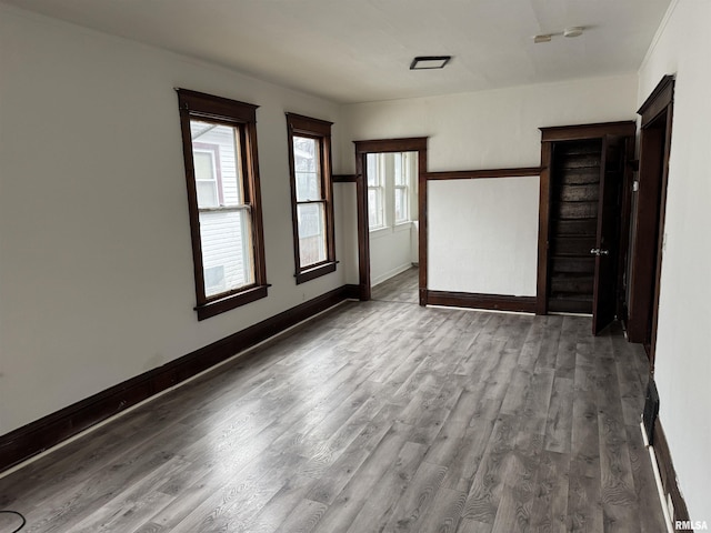 unfurnished room with baseboards and wood finished floors