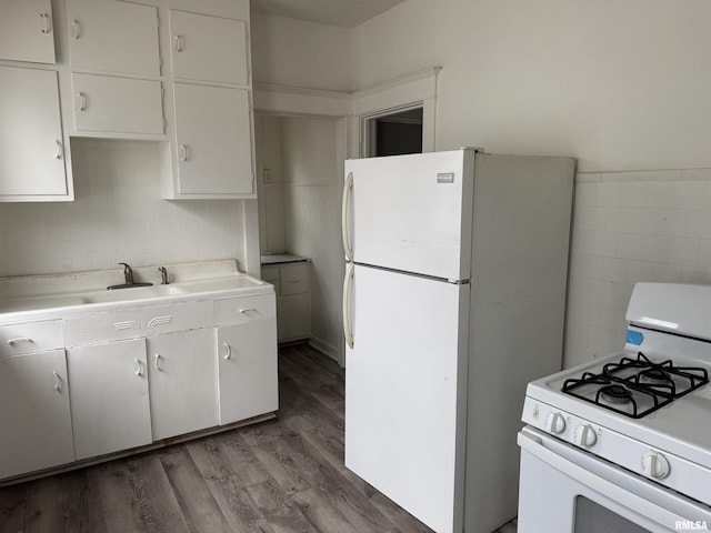 kitchen featuring tile walls, light countertops, white cabinets, wood finished floors, and white appliances