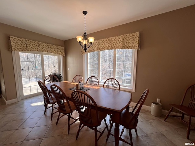 dining space with baseboards, light tile patterned floors, and a notable chandelier