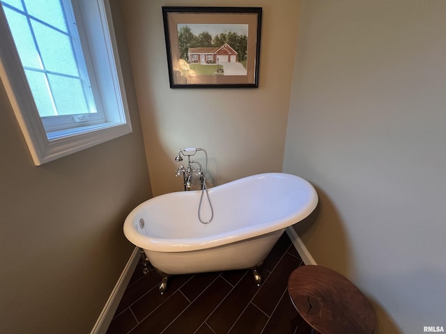 full bathroom featuring baseboards and a freestanding bath