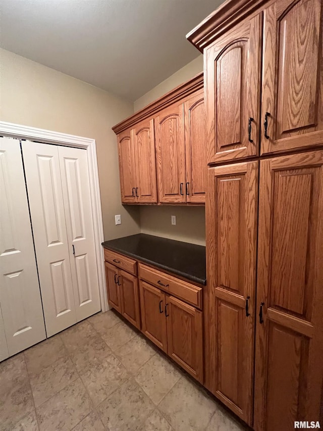 kitchen featuring brown cabinetry and dark countertops