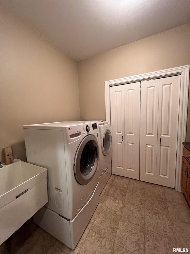 laundry area featuring laundry area, a sink, and independent washer and dryer