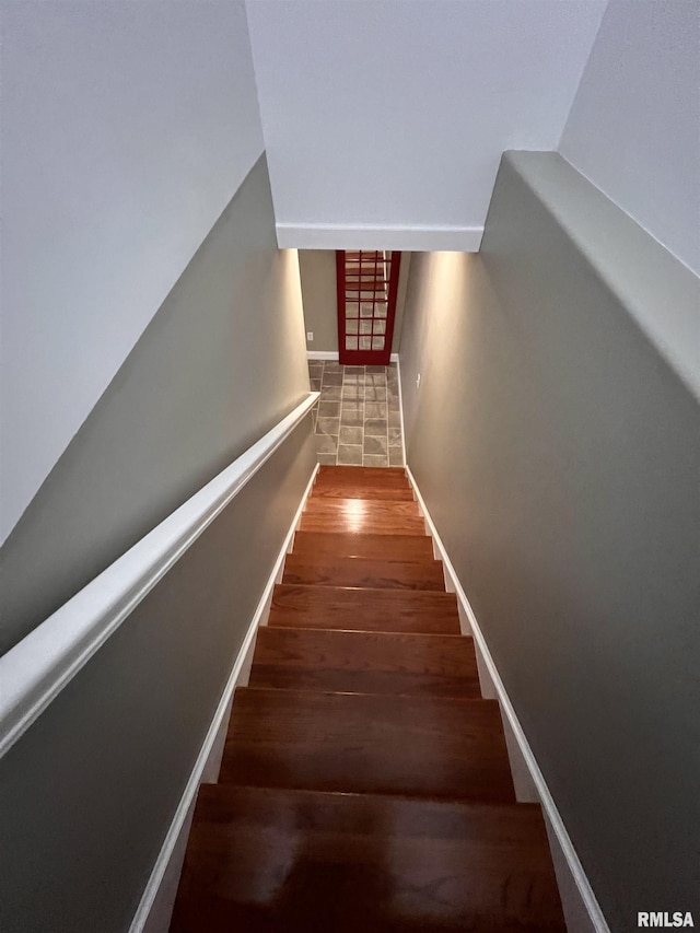 stairs featuring baseboards, vaulted ceiling, and wood finished floors