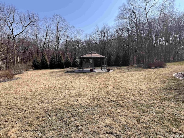 view of yard featuring a gazebo, a patio, and a view of trees