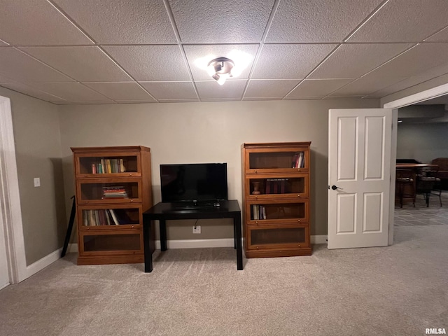 interior space featuring carpet floors, baseboards, and a drop ceiling