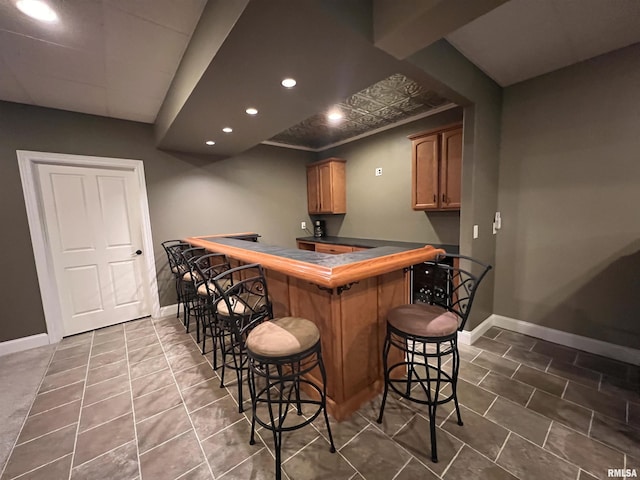 bar with dark tile patterned flooring, baseboards, bar area, and recessed lighting