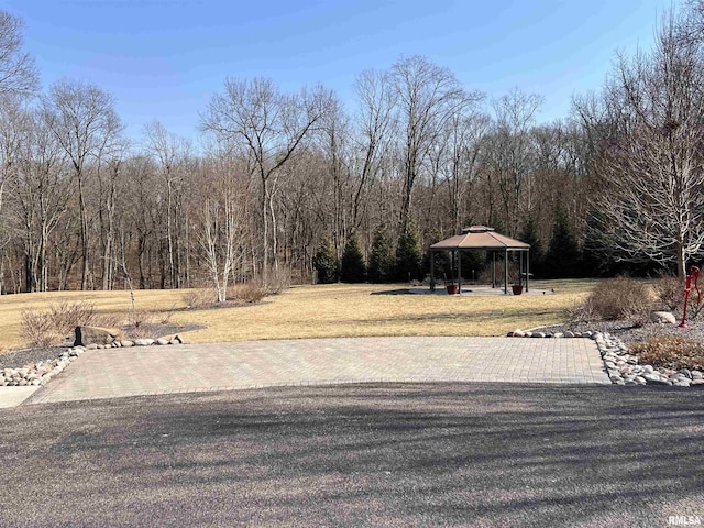 view of yard featuring a gazebo and a view of trees