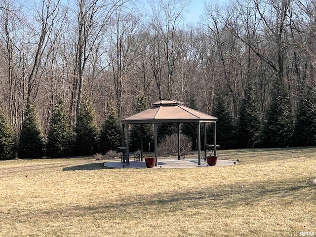 surrounding community featuring a wooded view, a lawn, and a gazebo