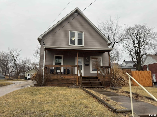 bungalow-style home with covered porch, a front yard, and fence