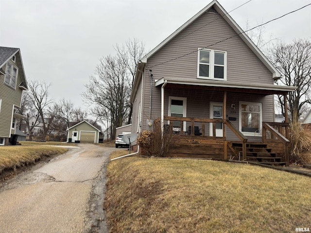 bungalow featuring an outbuilding, a porch, a front yard, and a garage