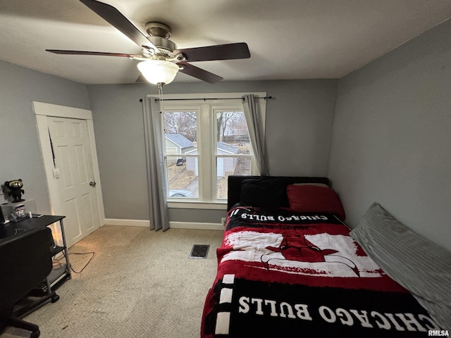 carpeted bedroom featuring ceiling fan, visible vents, and baseboards