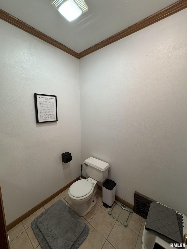 bathroom featuring toilet, baseboards, crown molding, and tile patterned floors