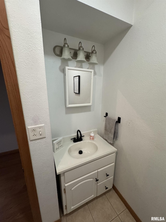 bathroom with tile patterned flooring, vanity, and baseboards