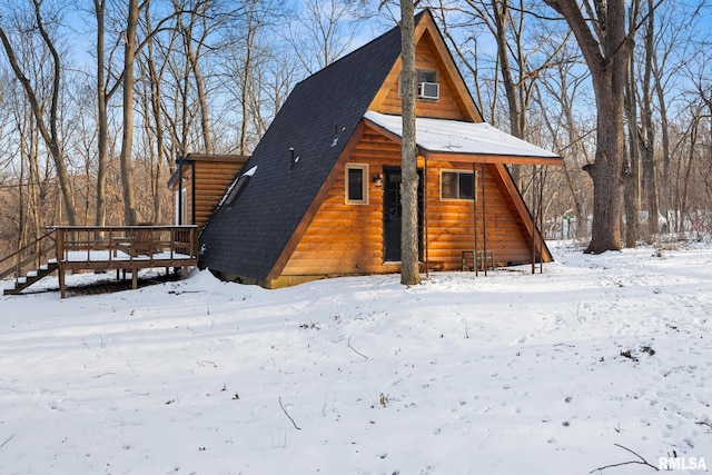 exterior space with a garage, roof with shingles, and a wooden deck