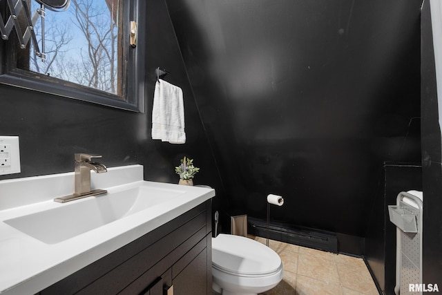 bathroom featuring a baseboard heating unit, vanity, tile patterned flooring, and toilet