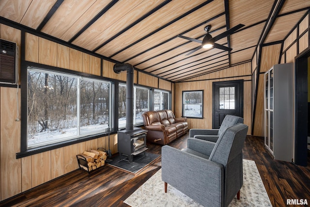 sunroom / solarium with a wood stove, a wall mounted air conditioner, a ceiling fan, and lofted ceiling
