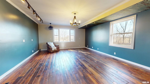 unfurnished room featuring dark wood-type flooring, a chandelier, crown molding, and baseboards