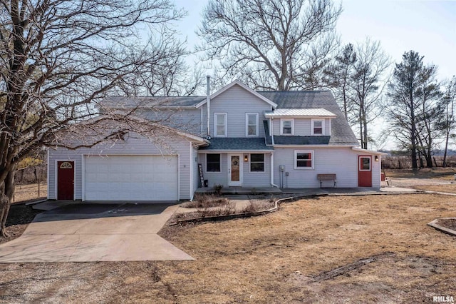 traditional-style house with a garage, roof with shingles, and driveway