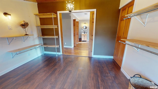 interior space with light countertops, an inviting chandelier, dark wood-type flooring, brown cabinetry, and baseboards