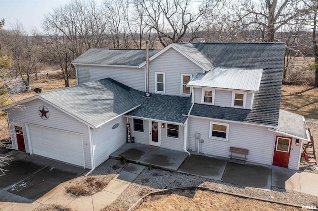 view of front of house with a garage, driveway, and a shingled roof