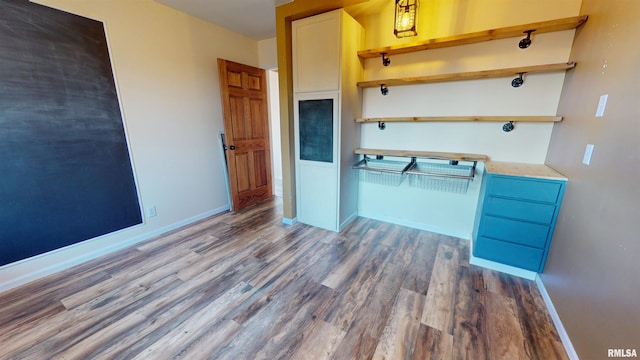 kitchen with open shelves, baseboards, and wood finished floors