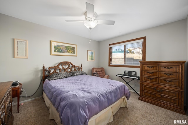 carpeted bedroom with ceiling fan and baseboards