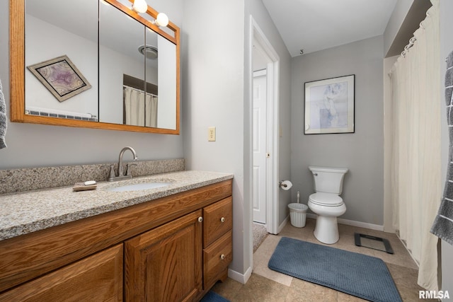 bathroom featuring baseboards, vanity, and toilet