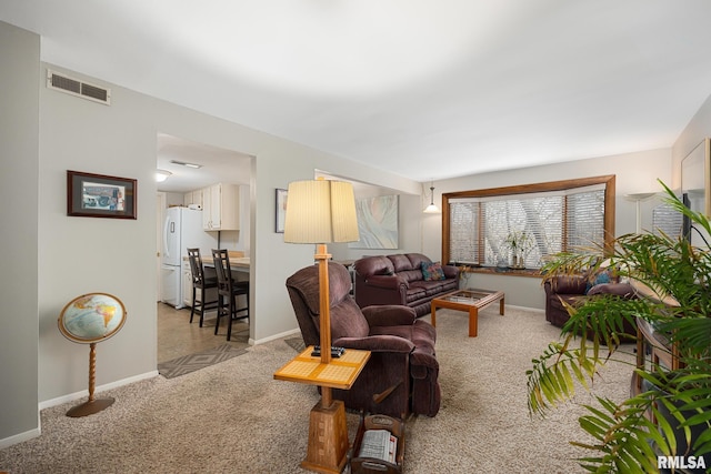 carpeted living area with baseboards and visible vents