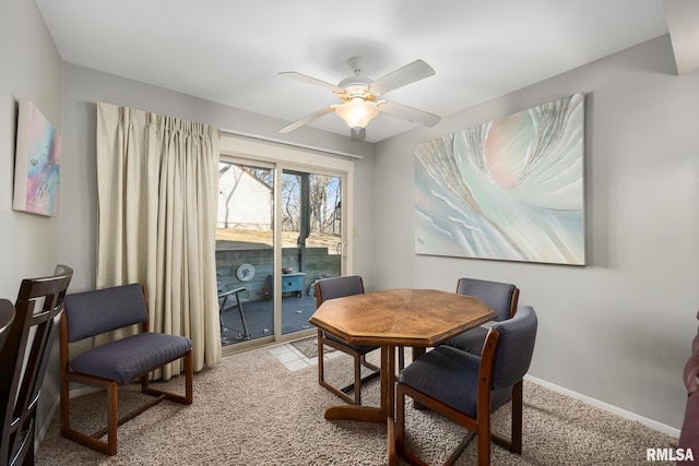 dining space with light carpet, ceiling fan, and baseboards