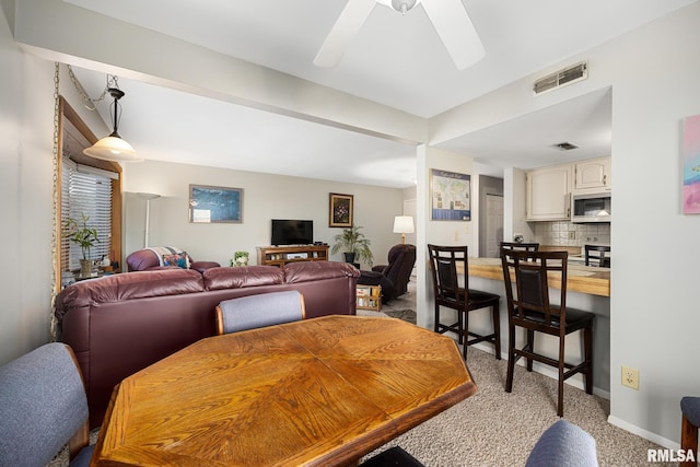 dining area featuring visible vents, ceiling fan, light carpet, and baseboards