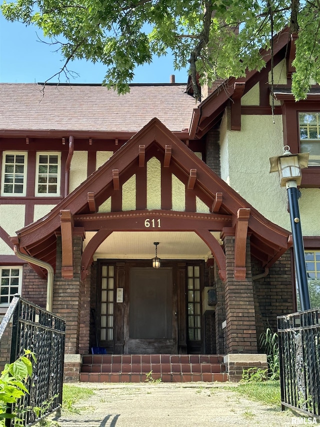 exterior space with covered porch, roof with shingles, and stucco siding