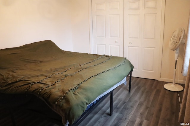 bedroom with dark wood-style floors and a closet