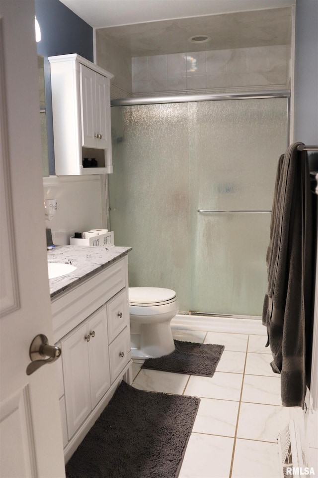 bathroom with tile patterned flooring, toilet, a shower stall, and vanity