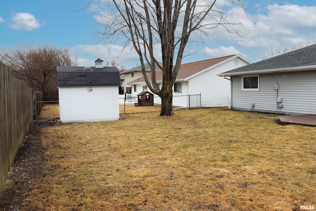 view of yard featuring a fenced backyard, a shed, and an outbuilding