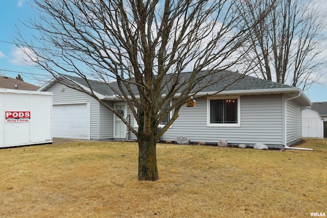 view of front of home featuring a storage unit, a front yard, an outdoor structure, and a shingled roof