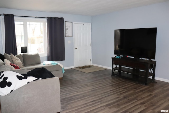 living area featuring baseboards and dark wood-type flooring