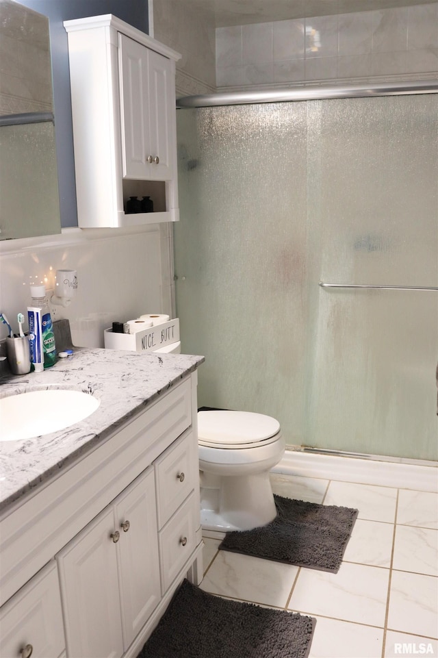 bathroom with toilet, a stall shower, and vanity