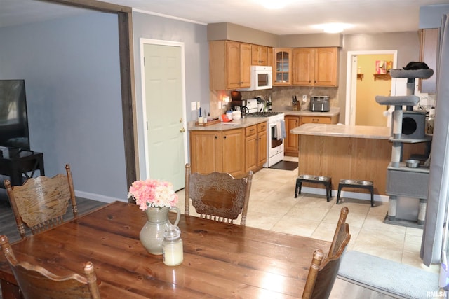 dining area featuring light tile patterned flooring and baseboards