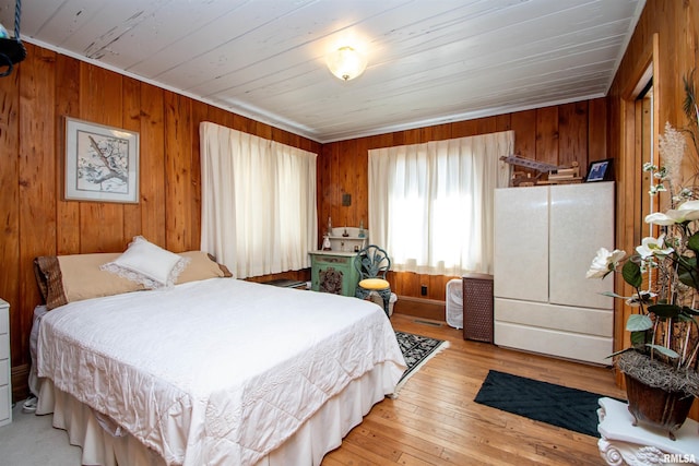 bedroom featuring wood walls and light wood finished floors