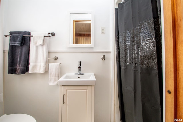 full bath with curtained shower, vanity, and toilet