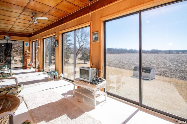 sunroom featuring wood ceiling and a ceiling fan