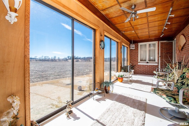 unfurnished sunroom with wooden ceiling, a ceiling fan, and track lighting