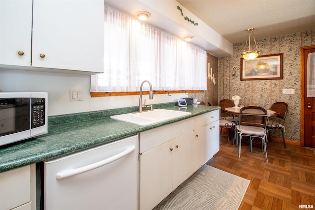 kitchen with dishwasher, stainless steel microwave, a sink, and wallpapered walls